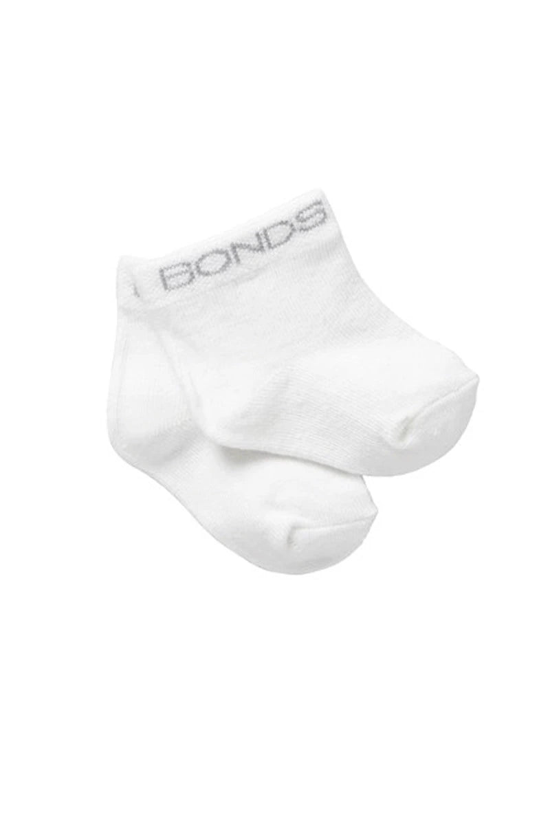 A pair of white ankle socks with the brand name 'BONDS' printed in gray on the top cuff, shown against a plain white background.